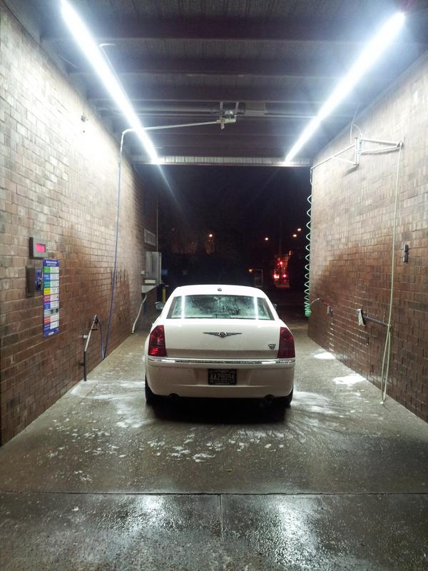 Dramatically LED-lit self-service car wash bay at night in Denver
